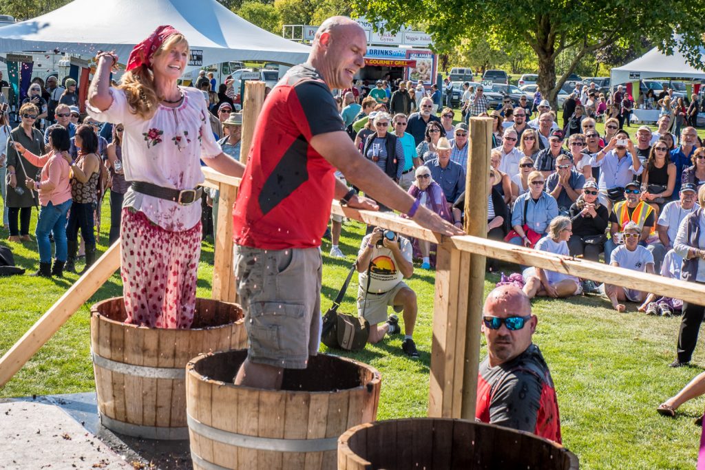 A contestant from the Ride to Survive team showers her opponents with grape mush during the Grape Stomp at Festival of the Grape. (Richard McGuire photo)