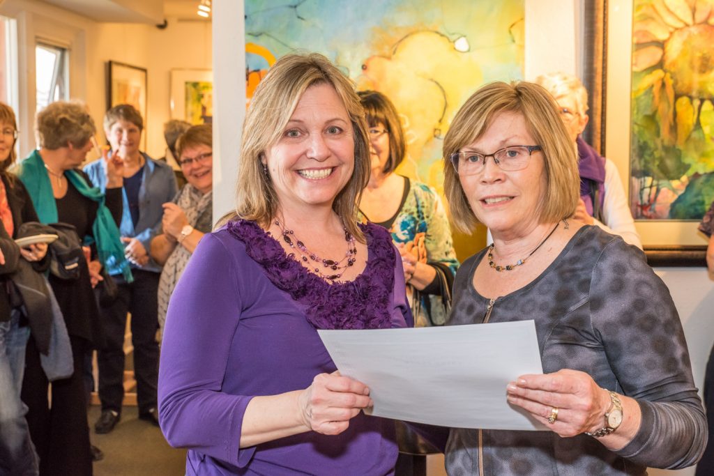 Georgia Krebs (right), president of the local chapter of the Federation of Canadian Artists (FCA), presents Summerland artist Diane Bennett-Way with one of two awards Saturday for her paintings in the FCA's juried show at the Osoyoos Art Gallery. Bennett-Way took first place for her painting "High Country" and third for "Canna It Be A Lily." Second place went to Marianne Meyer, of Naramata, for "I Will Show You the Way." Meyer also won two honourable mentions. The other honourable mentions went to Barbara Hofer of Okanagan Falls (two), and Peggy Stel of Penticton. (Richard McGuire photo)