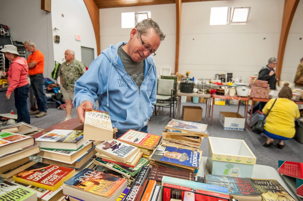 Howard Hebig checks out the used books at a garage sale Saturday at the Elks Hall. The sale was to raise money for the Canada Day fireworks display at Cherry Fiesta. (Richard McGuire photo)