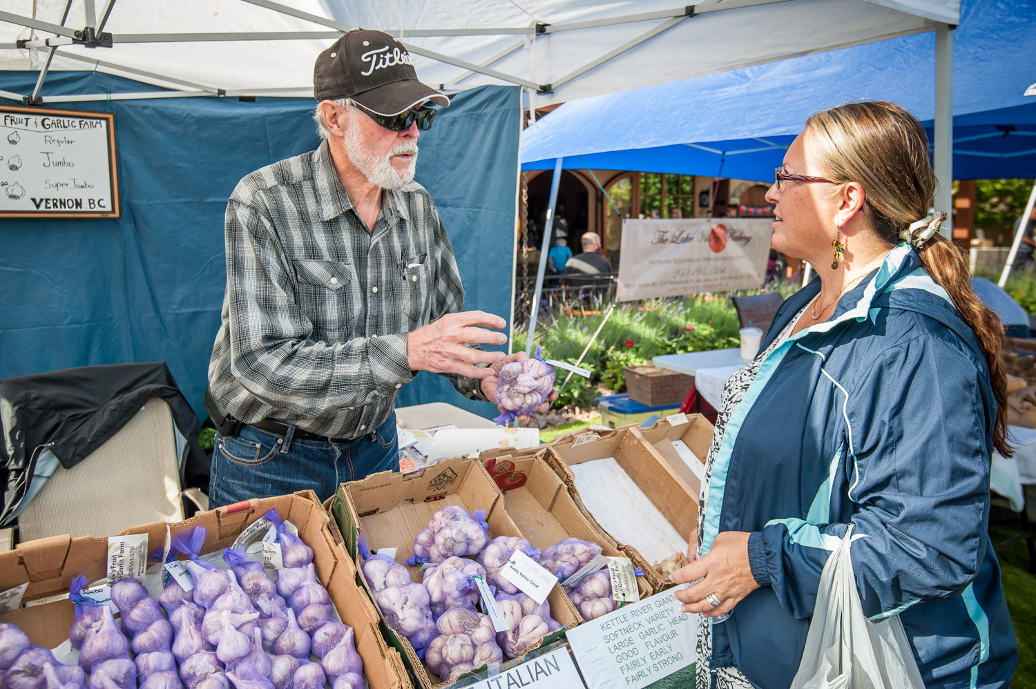 Keith Law of Law'w Fruit and Garlic Farm in Vernon talks garlic with Sandra Curnow of Penticton. The third annual Garlic Festival at Hester Creek Estate Winery attracted many foodies on Saturday. (Richard McGuire photo)
