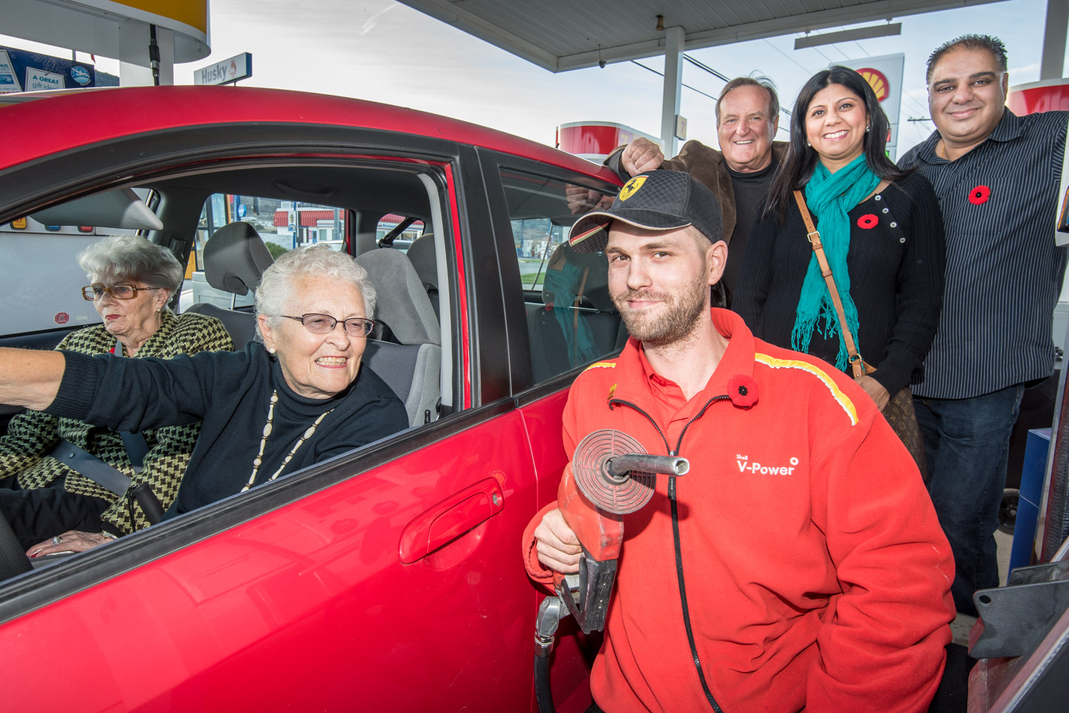 Lance Powers, assistant manager at the Shell service station, is ready to pump gas for senior Marlene West. In the background are Mayor Stu Wells, who went to bat for West, and service station owners Dal and Sat Brar. The Shell station will be offering full-service gas two days a week for seniors and anyone else who wants it for a small premium to help cover the cost of a second attendant. The Petro-Canada station at Nk’Mip Corner also offers seniors days. (Richard McGuire photo)