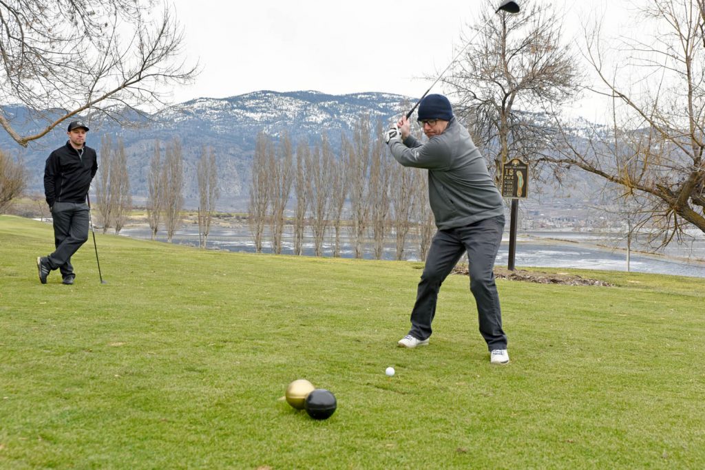 Billy Medwid tees off while We Greve looks on at the Osoyoos Golf Club. The course opened in early February. Both men are from Osoyoos. (Richard McGuire photo)