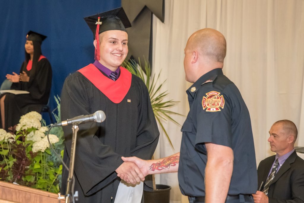Basketball coach and firefighter Casey Brouwer presents the Osoyoos Volunteer Fire Department award to Shayden Stark. Stark was on the Osoyoos Rattlers basketball team that Brouwer coached and is also a volunteer firefighter. (Richard McGuire photo)