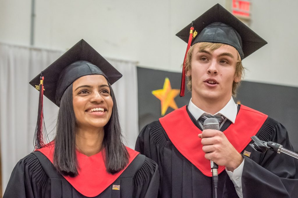 Valedictorians Parveen Chauhan and Cameron Kelm recall anecdotes from the grad class's experiences during their valedictory address. (Richard McGuire photo)