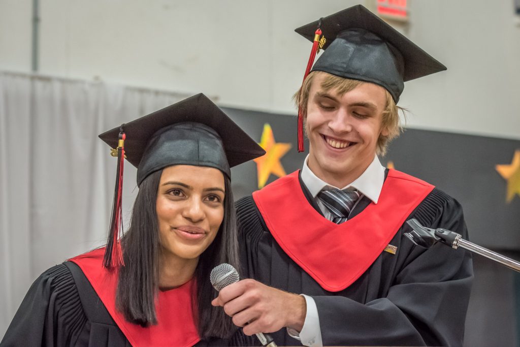 Valedictorians Parveen Chauhan and Cameron Kelm recall anecdotes from the grad class's experiences during their valedictory address. (Richard McGuire photo)