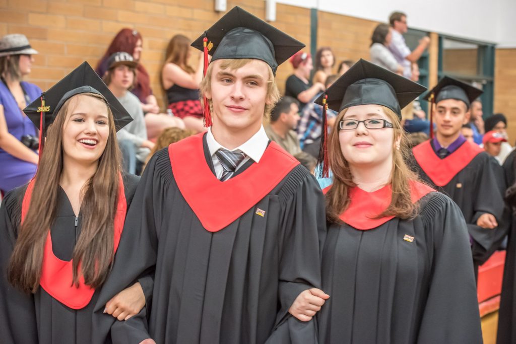 Graduates Ashley Burk, Cameron Kelm and Toni Petit parade through the gymnasium at the end of the ceremony. (Richard McGuire photo)