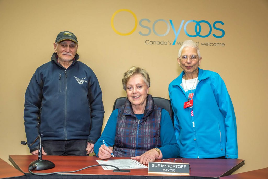Mayor Sue McKortoff last Friday proclaimed the month of February to be Heart Month in the Town of Osoyoos. She urged all citizens to “open their hearts” to the Heart And Stroke Foundation’s person-to-person campaign. At right is local campaign contact Sher Dastoor and at left is her husband Zubin Dastoor, who has been helping out. The volunteer-based health charity’s mission is to prevent disease, save lives and promote recovery. Funds raised support on-going heart disease and stroke life-saving programs and research. (Richard McGuire photo)