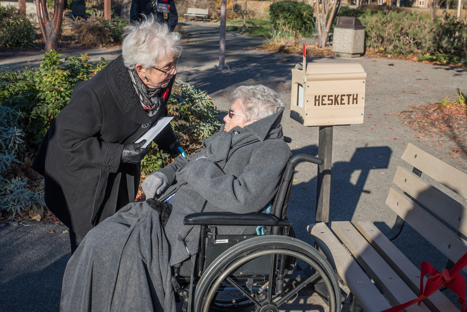 At the dedication of a commemorative plaque to Elfreda and Harry Hesketh last Wednesday, a letterbox was set up so that participants could leave letters of thanks. This was a fitting tribute to the couple, who served as postmasters in Osoyoos from 1946 to 1971. Shown here, Lynn Parsons (left) speaks with her older sister Elfreda before placing a letter in the box. Harry died in 2005, but Elfreda, known as Freda, now in her 90s, still lives at Mariposa Gardens. (Richard McGuire photo)