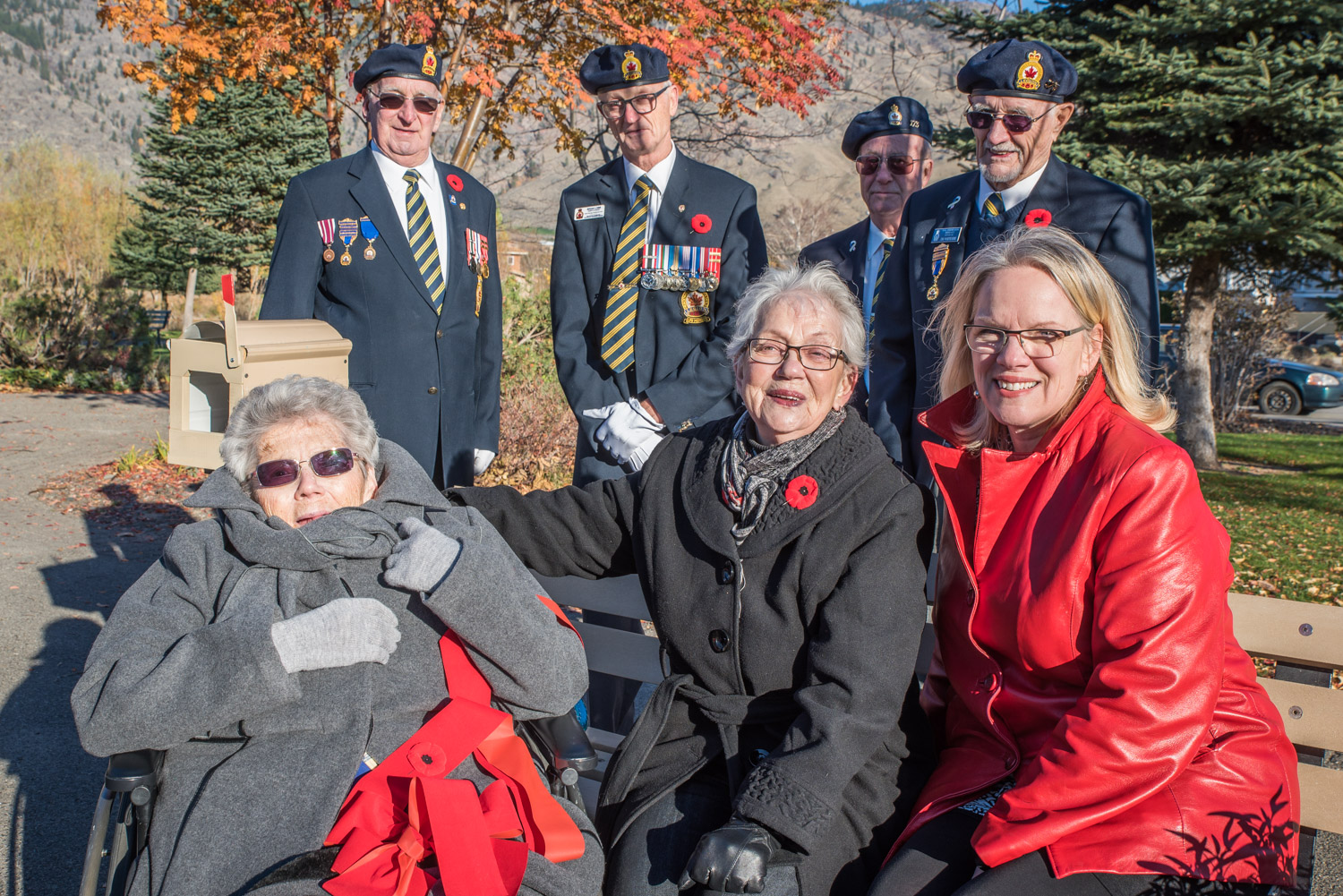 A ceremony was held last Wednesday at Cottonwood Park to dedicate a plaque and bench to Elfreda and Harry Hesketh, who served as postmasters in Osoyoos from 1946 to 1971. Elfreda, known as Freda, is pictured at bottom left with her sister Lynn Parsons and niece Cheryl Mantei. A colour party from the Royal Canadian Legion also participated in recognition of the Heskeths' active involvement in the Osoyoos branch. Elfreda was the first female member of the Legion. (Richard McGuire photo)