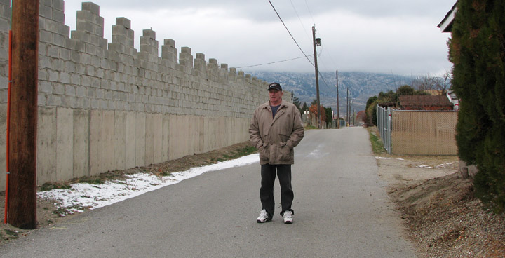 jackpineweb Phil Craft stands where he and other Jackpine Lane residents want a gate to be installed. A gate would block an area where the lane bottlenecks and turns into a wider street off of Tamarack Drive. The speed limit in the lane is 20 km/h, but Craft said he has seen drivers go as fast as 80 km/h. Photo by Tasleem Mawji - Click on picture for large image