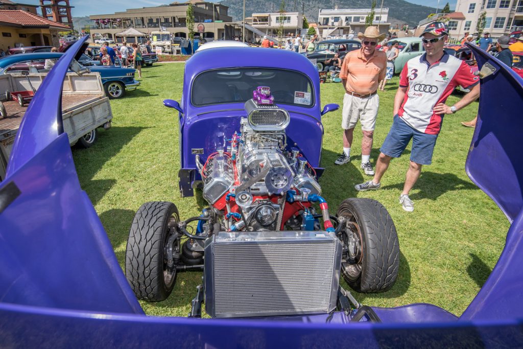 Bruce Treader (left), of Osoyoos, and Ian Ball, of Penticton, have a look under the hood of a custom 1941 Willy's. The hood extended far forward so people could admire the powerful engine. (Richard McGuire photo)