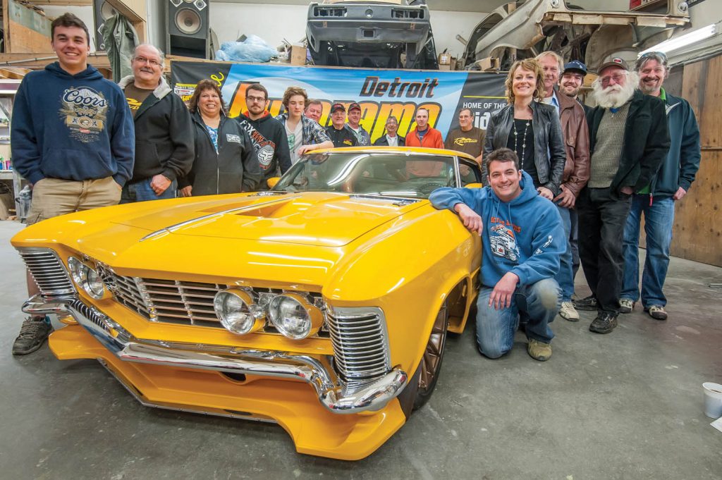 JF Launier, kneeing right of car, shows off the yellow 1964 Buick Riviera custom that won him the Ridler Award at Detroit Autorama. Posing with him are members of the team that worked on the car. (Richard McGuire file photo)