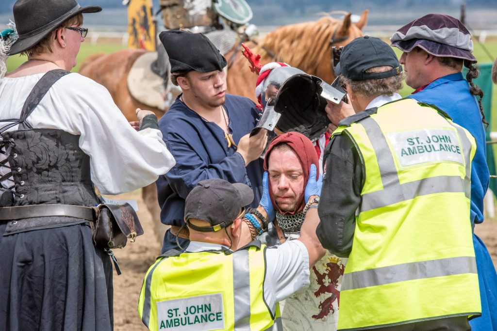Stephane Tremblay is checked by paramedics as squires helps remove his armour after he was struck in the face with a lance. (Richard McGuire photo)