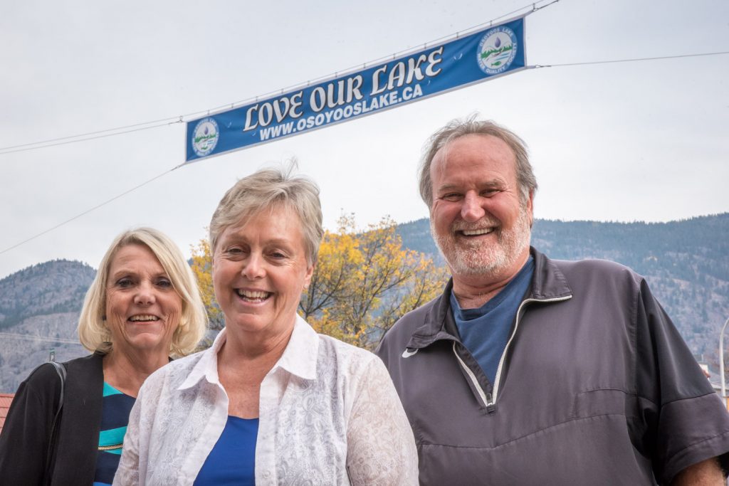 When participants in this week's Osoyoos Lake Water Science Forum drive down Main Street, they will be greeted by a big banner proclaiming Love Our Lake. The banner was sponsored by the Osoyoos Lake Water Quality Society (OLWQS), a citizens' group that monitors water quality. From left are Birgit Arnstein, president of OLWQS, and forum chairs Mayor Sue McKortoff and former mayor Stu Wells. Wells is also a director of the OLWQS. The forum runs from Wednesday to Friday with presentations at the Sonora Community Centre. (Richard McGuire photo)