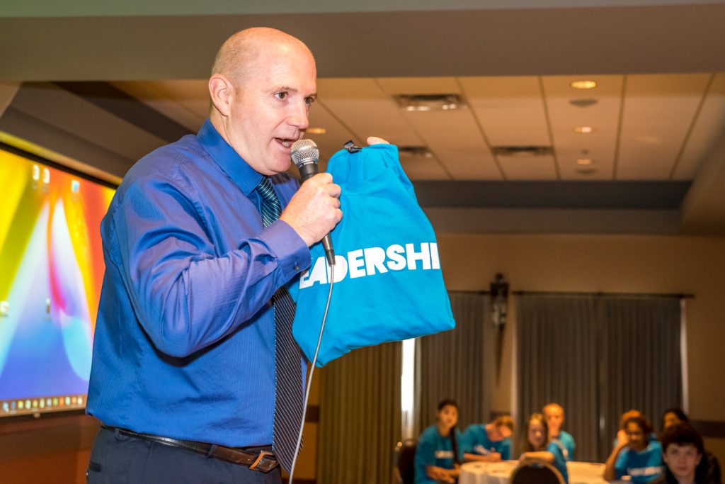 Osoyoos Elementary School Principal Dave Foster gives introductory remarks as he holds up a Leadership shirt. (Richard McGuire photo)