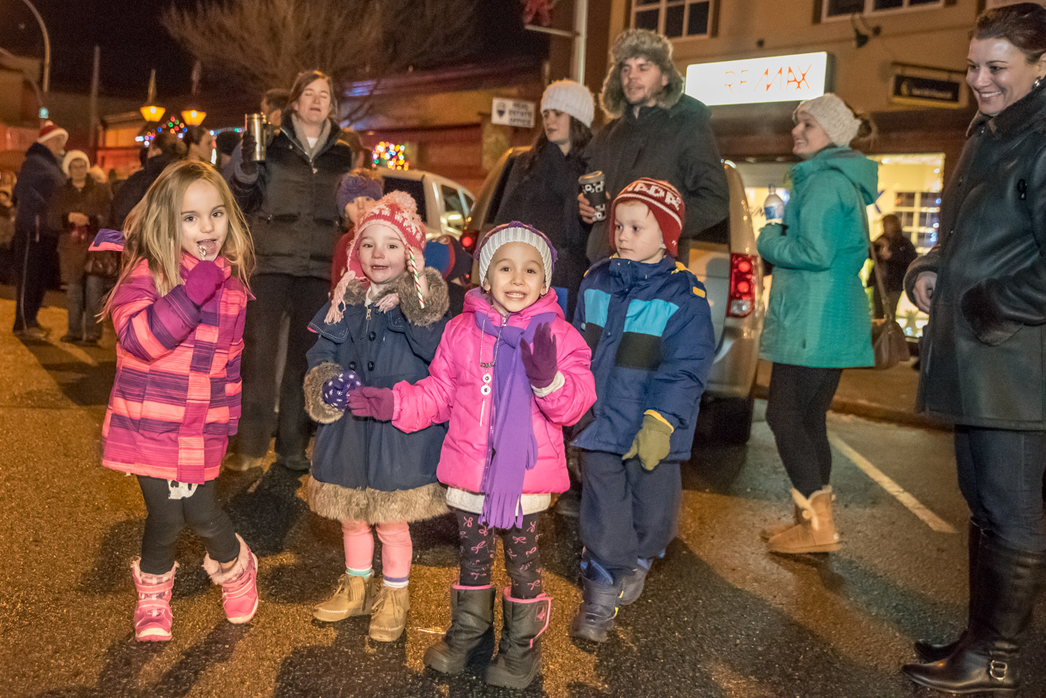 These children eagerly watch the parade and suck on candy canes handed out by Frosty the Snowman. (Richard McGuire photo)