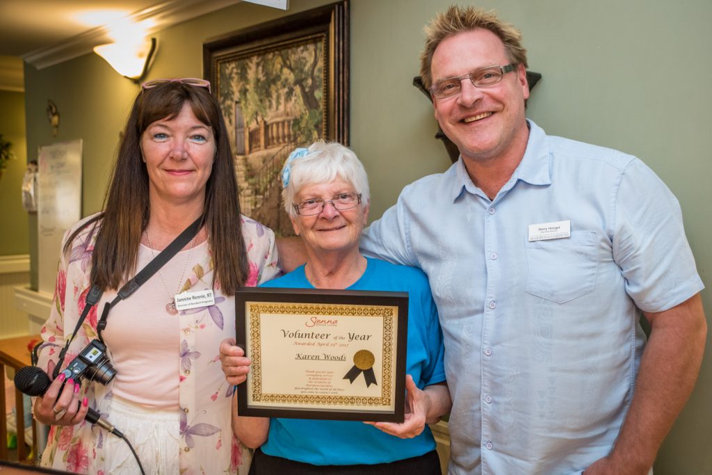Karen Woods was recognized last Tuesday as Volunteer of the Year at Mariposa Gardens. Presenting her with a plaque were Jannine Rennie, volunteer co-ordinator, and Barry Hengel, executive director at Mariposa Gardens. (Richard McGuire photo_