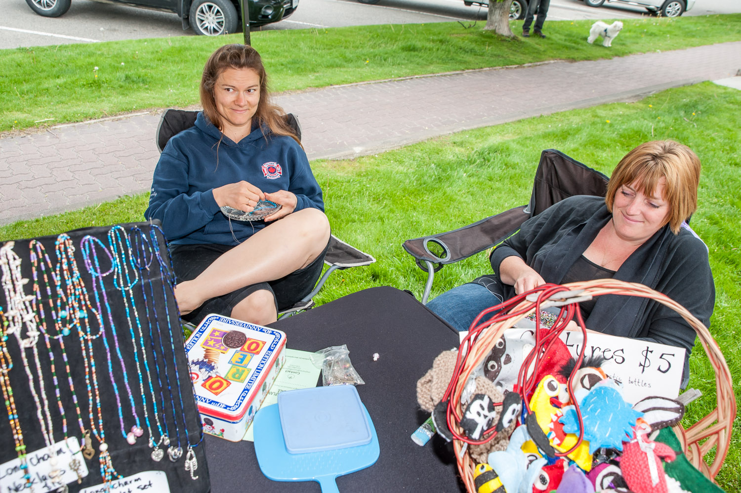 Sonya Schafer and Vanessa Blake, of Oliver, worked on beads and other crafts while they tended their booth at the opening of Market on Main on Saturday. (Richard McGuire photo)