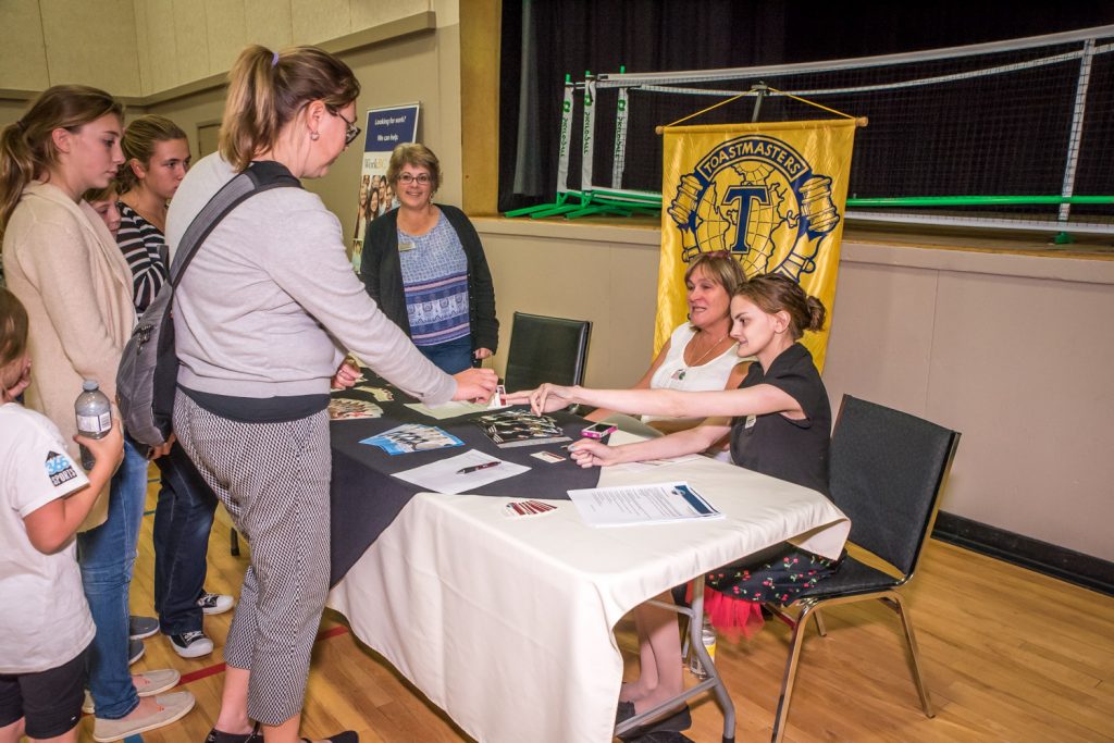 People stopped at the South Okanagan Toastmasters booth Wednesday night during the Mass Registration event at the Sonora Community Centre. The club meets Tuesday nights in Oliver, but has members from Osoyoos and Oliver. Behind the table from left are Shauna Burbidge, president, Barb Chipperfield, treasurer, and Chelsea Cameron-Horner, vice president public relations. The Mass Registration night gave local clubs and organizations a chance to sign up new members and do some public outreach. (Richard McGuire photo)