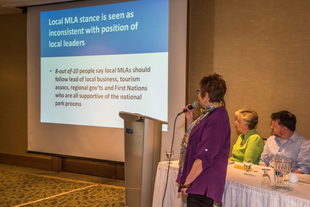Doreen Olson, co-ordinator of the SOS National Park Network, presents the results of an opinion poll about support for a national park. The slide she's showing suggests that MLA Linda Larson is out of step with local business, tourism associations, regional governments and first nations who support a park. Looking on are Osoyoos Mayor Sue McKortoff and Chamber of Commerce President Brian Highley, who were on a panel of individuals and organizations supporting the park. (Richard McGuire photo)