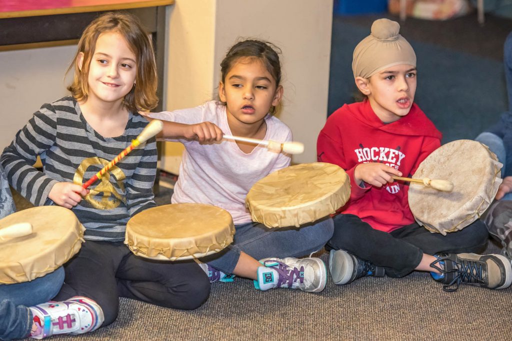 Led by drummer Tyler Williams from Vernon, children from Osoyoos Elementary School joined in during a session last Friday during the school's Okanagan Day. Children rotated to different classrooms to learn about Okanagan culture. From left are Haylee King, Jasleen Dhaliwal and Aditya Samra. (Richard McGuire photo).