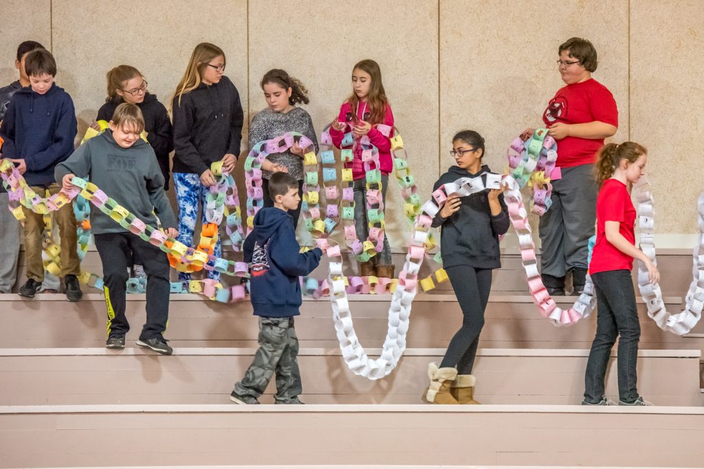 Osoyoos Elementary School students bring a "chain of kindness" down from the bleachers to circle their fellow students at a wrap-up rally for the school's 21 Days of Kindness. (Richard McGuire photo)