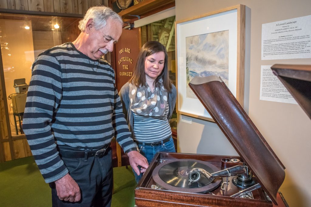 Allan Gaudreault show the Victor VV-IX "Victrola" tabletop phonograph he restored for Osoyoos Museum, while Manager Kara Burton looks on. The phonographs will be playing when the museum holds an open house on Saturday. (Richard McGuire photo)