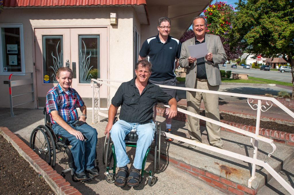 Osoyoos Mayor Stu Wells (right) read a statement proclaiming June 7 as Access Awareness Day in Osoyoos. Joining him from left are Mike Stiles, Dan Bauer and Community Services Director Gerald Davis. The day is intended to raise awareness of the importance of designing community facilities so that people with disabilities have access to them. The entrance to town hall has a ramp for those using wheelchairs. Stiles and Bauer would like to see better disabled access to the lake for activities such as swimming and kayaking. (Richard McGuire photo)