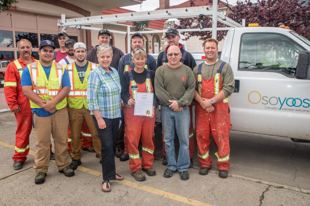 Mayor Sue McKortoff (front, centre) declared the week of May 17 - 23 as Public Works Week in Osoyoos. The week recognizes the important contribution of public works infrastructure, facilities and services and the staff who work to provide them. Pictured are Town of Osoyoos Public Works employees. Back from left: Frank Zandvliet. Mark Paolera, Dave Stene, Leigh Lougheed, Karl Fichter and Wyatt Nelmes. Front: Wayne Harfman, P.J. Maddalena, Mayor McKortoff, Helen Pain, Ron Doucette (Director of Operational Services) and Brad Garska. (Richard McGuire photo)