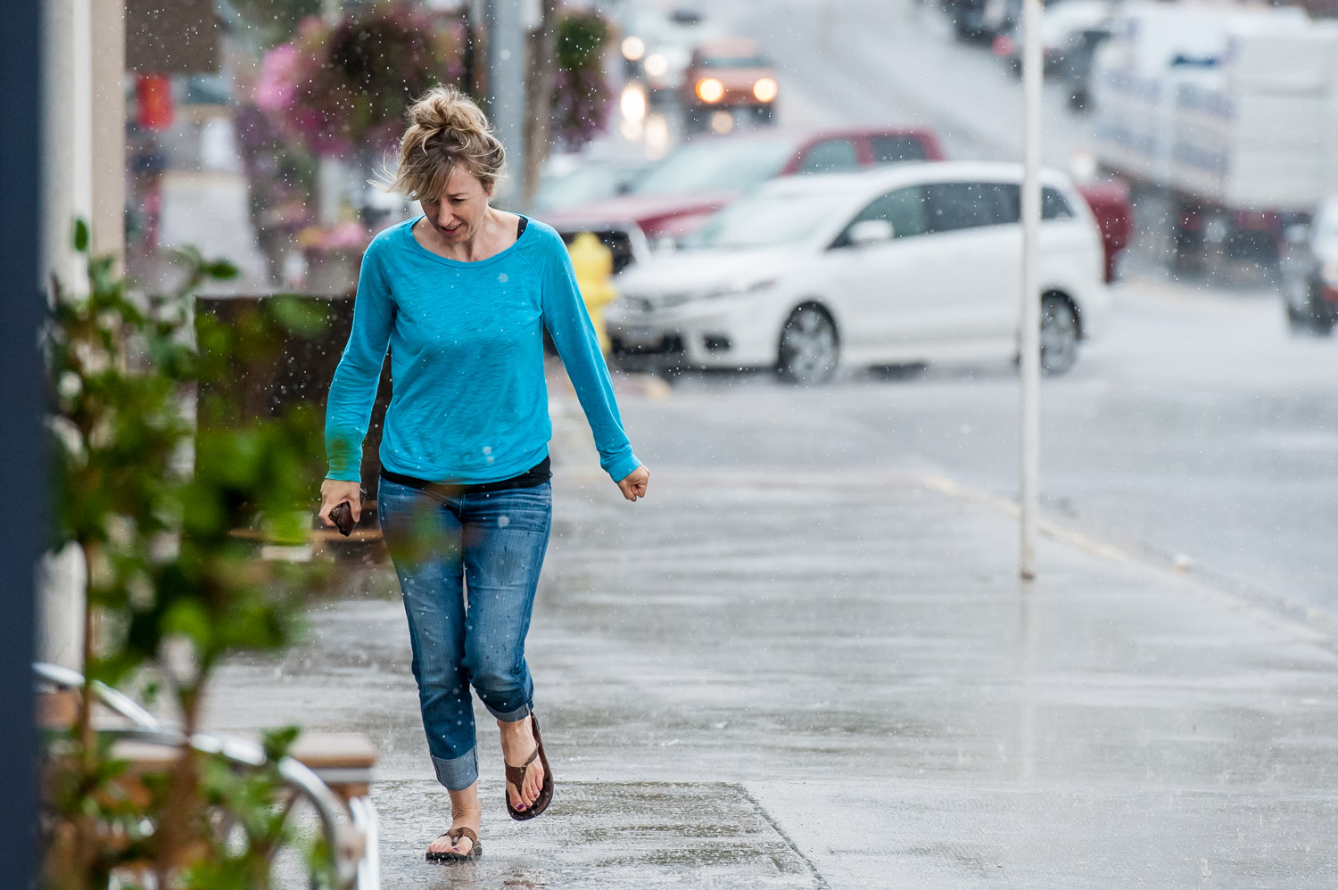 A woman makes her way up Main Street in pouring rain last Wednesday. Many parts of the southern Interior, including Osoyoos, saw heavy rains and lightning storms. The storms helped to dampen wildfires and also brought cooler temperatures that allowed the salmon migration to pick up. Some were inconvenienced when power outages occurred, soil eroded and the Wednesday evening Market on Main was cancelled. Hot, clear and dry weather is predicted for the remainder of this week. (Richard McGuire photo)