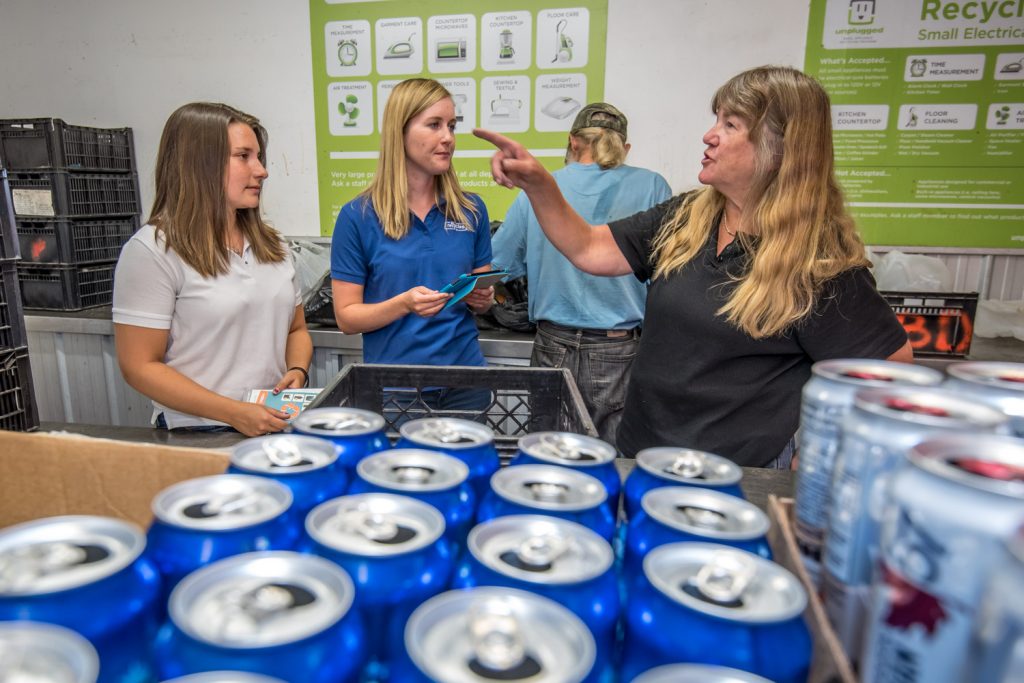 BC Recycles Summer Ambassadors Ali Russell (left) and Sara Pratt (centre) were in Osoyoos last Thursday to meet with businesses the collect products for recycling. Shown here they dropped in to the Osoyoos Bottle Depot where they discussed recycling with owner Sandy Palmateer (right). The two ambassadors also visited automotive shops that handle oil and other products for recycling as well as Home Hardware. They are reporting what they hear to the directors of product care at BC Recycles. Their trip this year did not include public outreach, but the two are promoting a BC Recycles app available for Android at Google Play and for Apple at the App Store. (Richard McGuire photo)