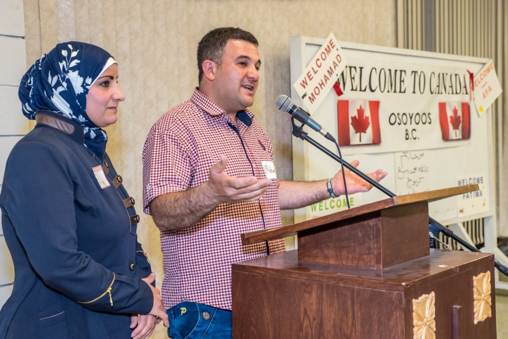 Mohamad extends thanks to all those who have helped the family settle in Osoyoos and learn English while his wife Aya looks on. She and the children, Fatima and Samer, each took a turn at the mic to say "Thank you." (Richard McGuire photo)