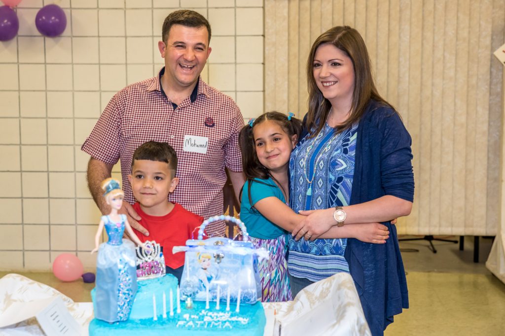 Fatima embraces her Grade 3 teacher Julie Dias while Mohamad and son Samer stand behind Fatima's cake for her ninth birthday. (Richard McGuire photo)
