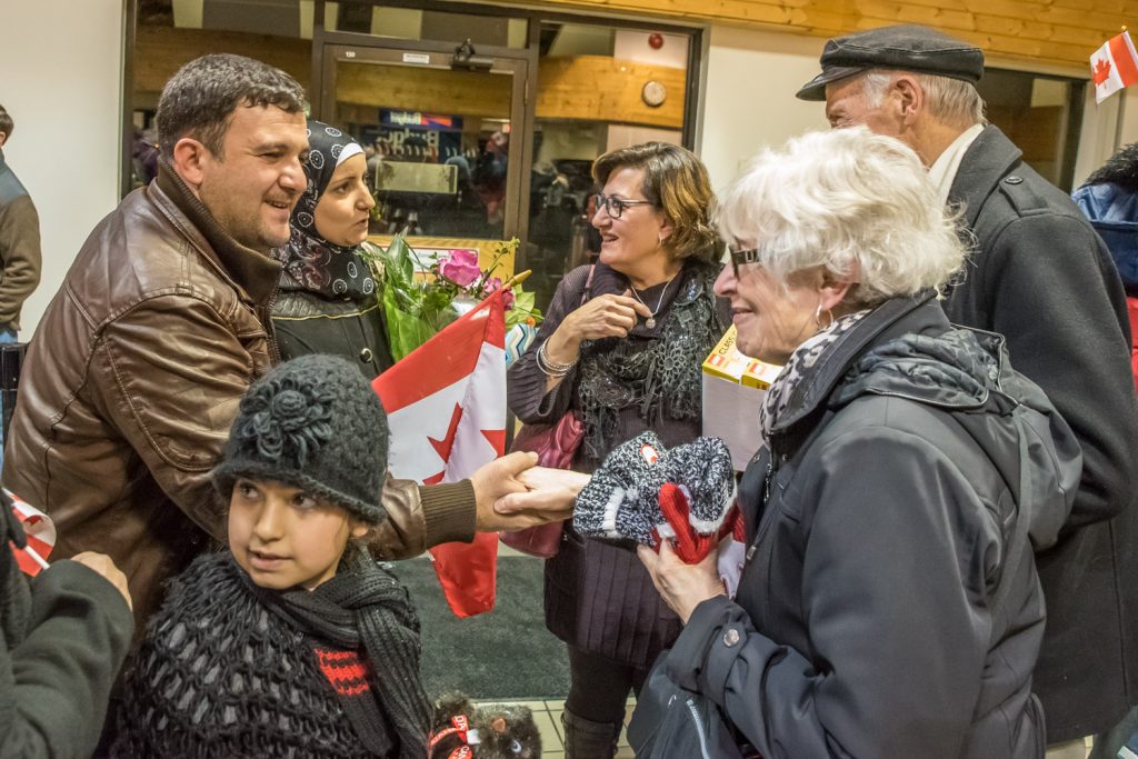 Vera and Michael Ryan, right, greet Mohamad Rabee Tabanjat and his wife Aya. In front at left is their daughter Fatima, 8. (Richard McGuire photo)