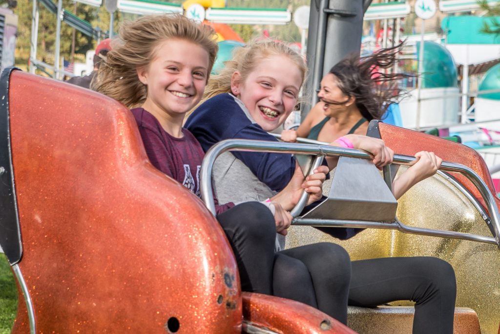 These girls were having fun spinning around at high speeds and getting dizzy on the Sizzler at Rock Creek Fall Fair on Sunday. (Richard McGuire photo)