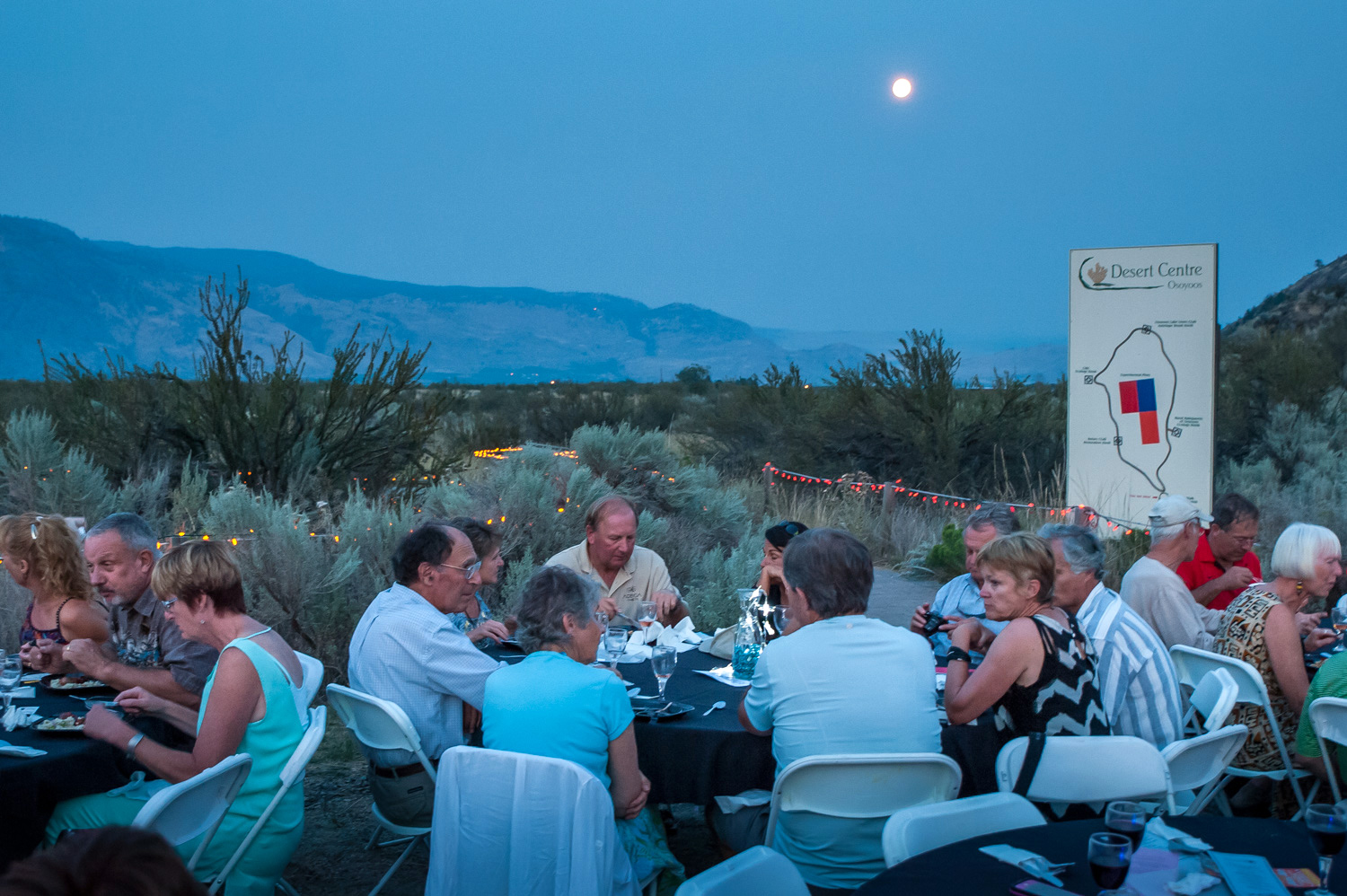 As a full moon rises in the sky, guests dine at the plaza at the Osoyoos Desert Centre on Saturday night. The official full moon the following night is called a supermoon because the moon was at its closest orbit to the earth, making it appear larger. (Richard McGuire photo)