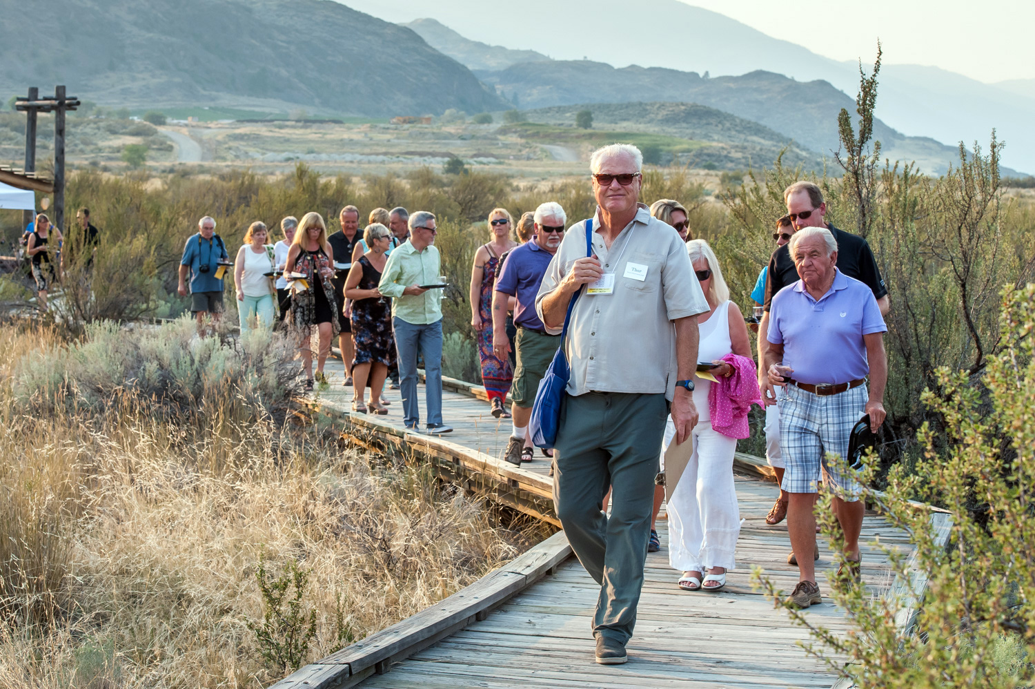 A group of guests walks along the boardwalk through the desert at the Osoyoos Desert Centre during Romancing the Desert on Saturday. Guests walked between food and wine stations while a guide told them about the desert. The event is a fundraiser for the Osoyoos Desert Society. (Richard McGuire photo)