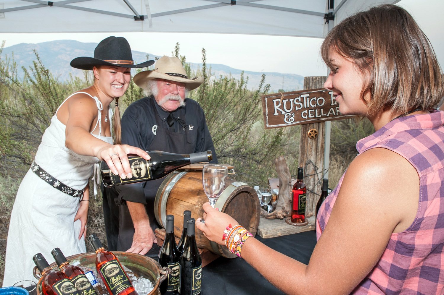 Sue Rorsin and Bruce Fuller of Rustico Farm and Cellars pour wine for a guest at a wine station at Romancing the Desert. Guests followed the boardwalk through the desert stopping at food and wine stations and hearing a guide speak about the desert. (Richard McGuire photo)