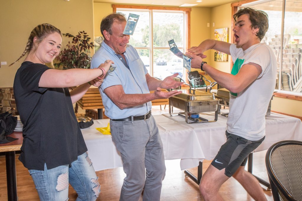 Lukáš Kršek, right, from the Czech Republic, showered Trevor Caldecott with $50 in cash from his 50-50 winnings and Olivia Greenwood-Jack, left, from Australia did the same with her $45 winnings. The Rotary exchange students made the gesture of support after hearing Caldecott’s presentation about the oppressed Dalit people in India and the work done by the Dalit Freedom Network Canada to support the education of Dalit children. (Richard McGuire photo)