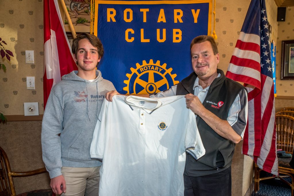 Carlo Geat, a 17-year-old Rotary Youth Exchange student from northern Italy, spoke to Osoyoos Rotarians last week about his experiences. Presenting him with a shirt was Brian Rawlings, president of the Rotary Club of Osoyoos. (Richard McGuire photo)