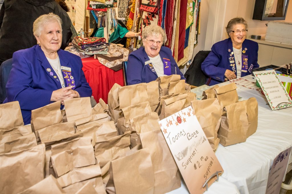 These ladies in Osoyoos Royal Purple were welcoming visitors, selling toonie surprise bags and sharing a few laughs at the Osoyoos Royal Purple Christmas Craft Fair. From left are Theresa Reiter, club historian; Margaret Hogg (formerly Petrin), lecturing lady; and Anne Stappler, honoured royal lady. The craft fair had a number of local vendors on both the main floor and basement at the Elks Hall, many selling homemade crafts and food items. (Richard McGuire photo)
