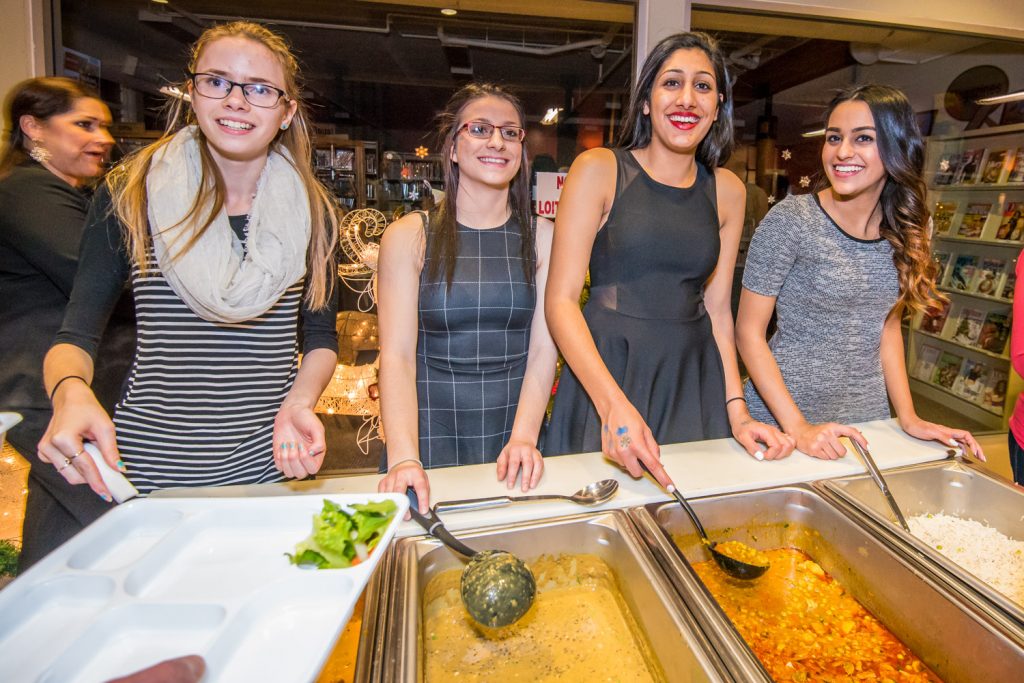 An Indian dinner was one of the highlights at Santa's Night Out, an Osoyoos Secondary School dry grad fundraiser at the Sonora Community Centre Friday night. Serving from left are Rachel Gross, Chelsey Bridgeman, Nimrit Dhaliwal and Pawan Rai. (Richard McGuire photo)