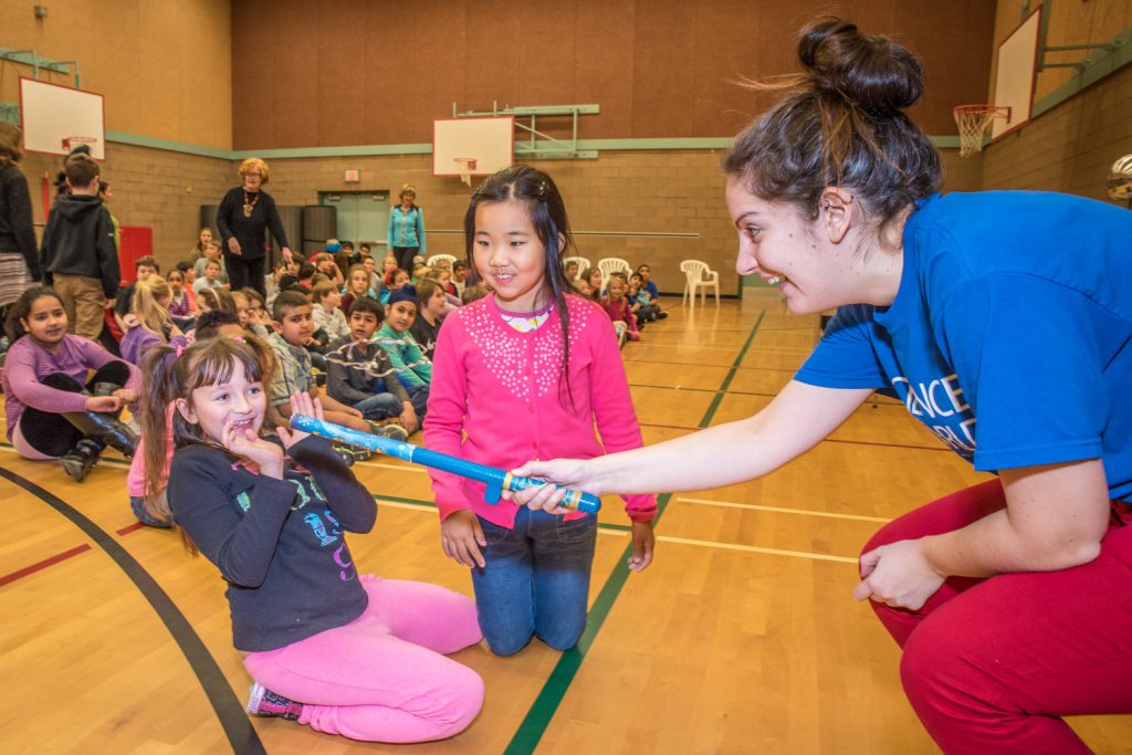 Charlotte Swanson (right) shows Kaylie Lino and Cindy Jia how a floating loop of foil is attracted to people by static electricity, but is repelled by her rod. (Richard McGuire photo)