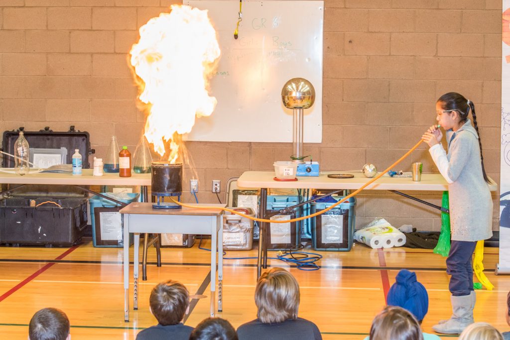Prabhnoor Samra blows into a tube causing a fiery mushroom cloud as lycopodium ignites. The demonstration led to comparisons of how the dry weather and sun's heat made vegetation flammable last summer. (Richard McGuire photo)