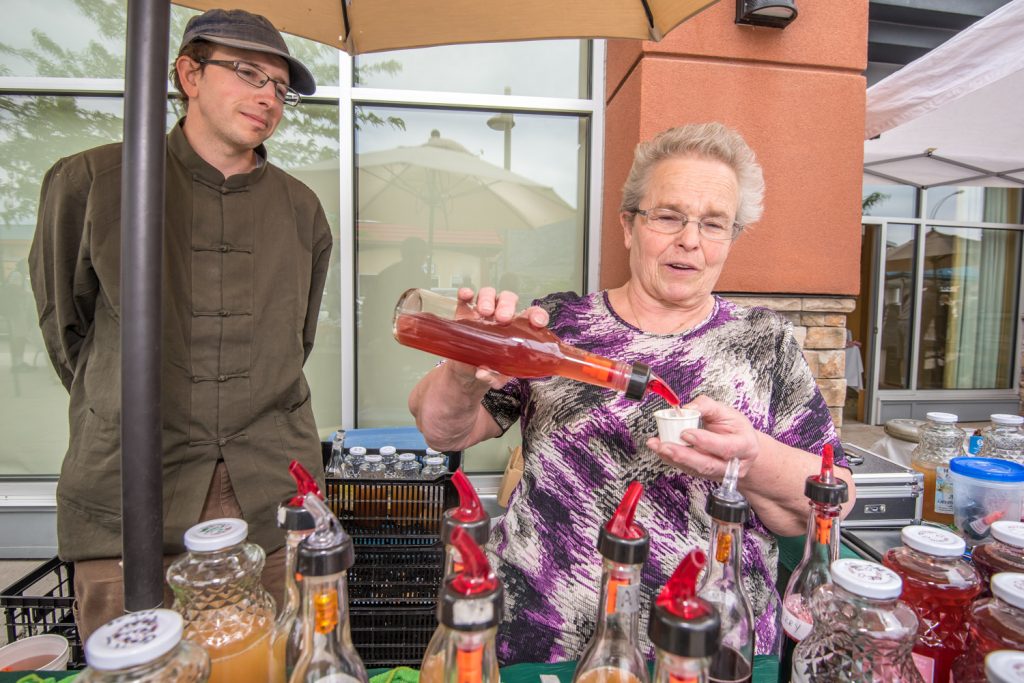 Slow food is the opposite of fast food -- it uses handcrafted, organic and generally wholesome ingredients. For the fourth year in a row on Sunday slow food vendors held a market in front of the Watermark Beach Resort. Pictured here, Brante Farrell, owner and managing director of Westbank Harvest, looks on while his mother Selina Farrell pours a sample of grape juice. The Annual Market of Taste by Slow Food Thompson Okanagan was held in conjunction with the Devour! Food Film Festival, which is making a cross-country stopover in the Okanagan Wine Country this year. (Richard McGuire photo)
