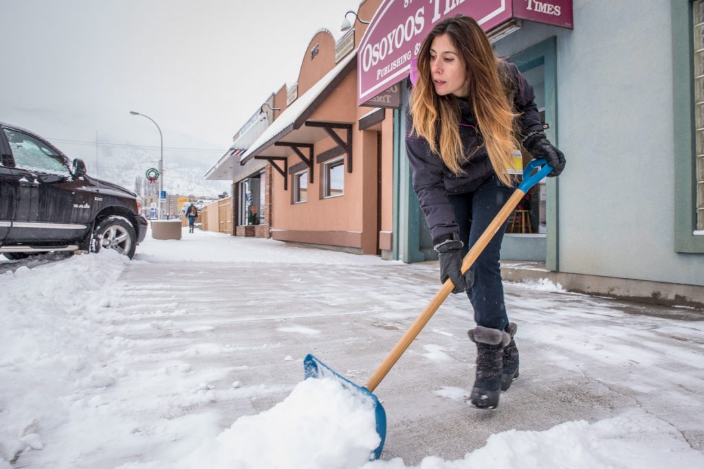 As snow continued to fall slowly, but steadily on Monday, Ronda Jahn, senior ad designer at the Osoyoos Times, made repeated trips to shovel the sidewalk. (Richard McGuire photo)