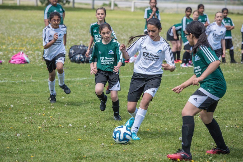 Navneet Gill of the Osoyoos U-11/12 girls soccer team dribbles the ball downfield while Oliver players Nimrit Sidhu, left, and Abbi Mantua, right, give chase at Tuc El Nuit Elementary School in Oliver. (Richard McGuire photo)