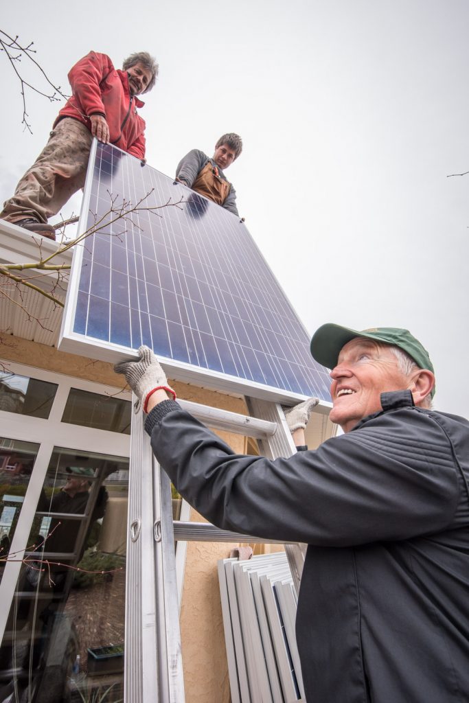 Paul McCavour hands up a solar panel to Roger Huber (left) and his son Franco. The Hubers, of Swiss Solar Tech were installing panels at the Osoyoos home of Jerry McKay and Nancy Fath. (Richard McGuire photo)