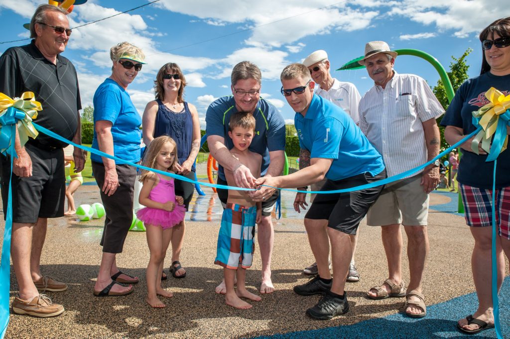 Brody McLean cuts the ribbon to officially open the Osoyoos Splash Park with help from Splash Park Committee co-chairs Gerald Davis and Coun. Mike Plante. Behind are (from left) Mayor Stu Wells, Coun. Sue McKortoff, Kirsten McLean, Davis, Plante, Coun. Michael Ryan, Jim King and Tamara Morgan. (Richard McGuire photo)
