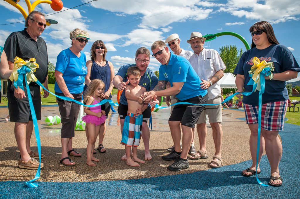 Brody McLean cuts the ribbon to officially open the Osoyoos Splash Park with help from Splash Park Committee co-chairs Gerald Davis and Coun. Mike Plante. Behind are (from left) Mayor Stu Wells, Coun. Sue McKortoff, Kirsten McLean, Davis, Plante, Coun. Michael Ryan, Jim King and Tamara Morgan. (Richard McGuire photo)